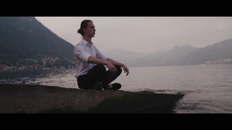man meditating by a lakeside