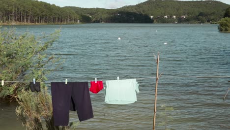 ropa colorida colgada en el tendedero a orillas del río, entorno rural