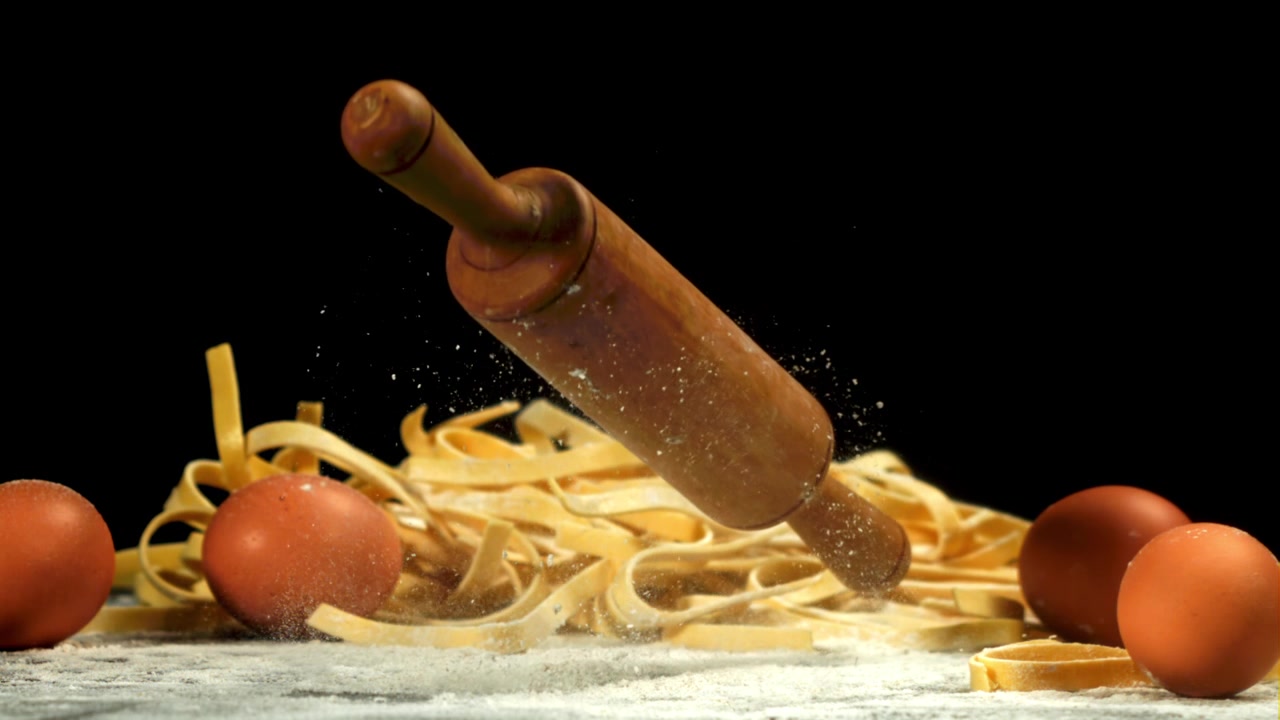 Mattarello che cade su pasta fresca e farina al rallentatore