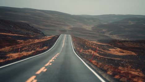 drive on the narrow road through the harsh tundra landscape on a rainy day