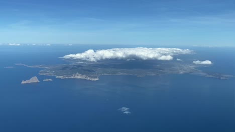 ibiza island from a cockpit´s plane during the approach during the day covered with clouds