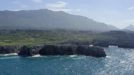 Misty-green-lush-mountains-of-bufones-de-pria-asturias-spain-stunning-blue-water,-wide-aerial-dolly