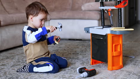 child engaged in pretend play with tools. a young child sits on the floor playing with toy tools at a small workbench, enhancing creativity and motor skills