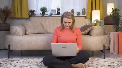 mujer concentrada trabajando en una computadora portátil.