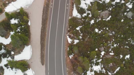 top down shot of a road in the snowy mountains in austria