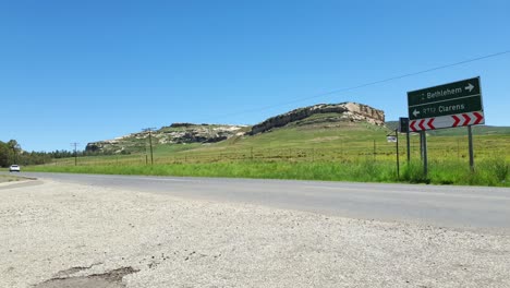 R712-road-outside-Clarens-town-in-Free-state-province-South-Africa-with-cars-and-motorbike-traffic-traveling-past-on-vacation-in-Moluti-Mountains