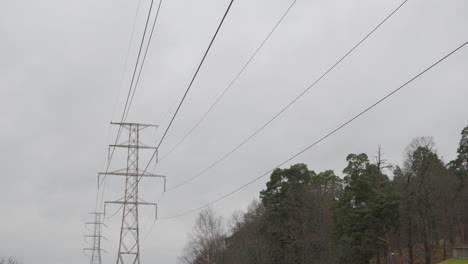 Líneas-Eléctricas-De-Alto-Voltaje-Que-Atraviesan-Bosques-Suburbanos,-Inclinación-Lenta