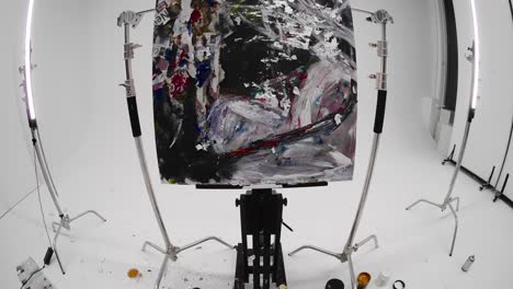 large abstract painting in studio, captured with fisheye lens. slow-motion clip showing paint on the floor and detailed view of contemporary artwork. artistic environment highlighting creative process