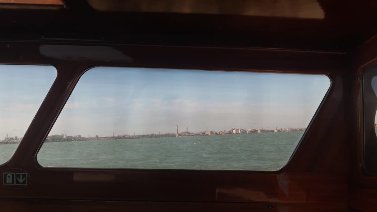 지평선에 있는 베네치아 시는 빠르게 움직이는 배에서 틴의 오두막 안에서 볼 수 있습니다.