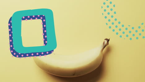 composition of abstract shapes over banana on yellow background
