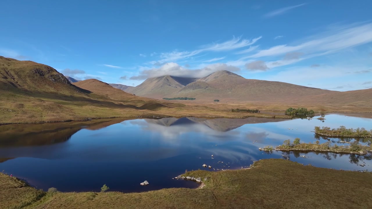 La montaña Meall a' Bhùiridh reflejada en las tranquilas y oscuras aguas de Lochan na h-Achlaise, Rannoch Moor, Glencoe.