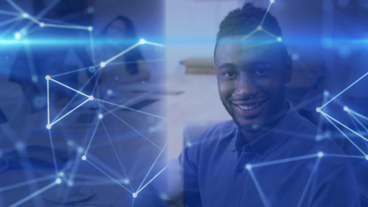 Man sitting at business table shifting from neutral to smiling as blue network overlay sliding