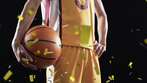 animation of confetti falling over caucasian female basketball player with ball on black background