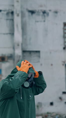 atomic survivor in post apocalyptic setting. portrait of guy in gas mask on the background of ruined abandoned building