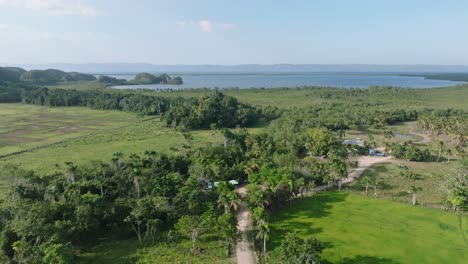 Aerial-flyover-beautiful-green-landscape-of-Dominican-Republic-with-Caribbean-Sea-in-background-during-sunny-day