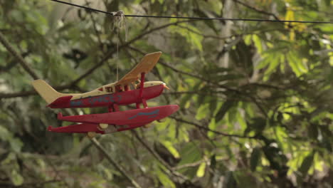 close-up of plastic red airplane with jungle background