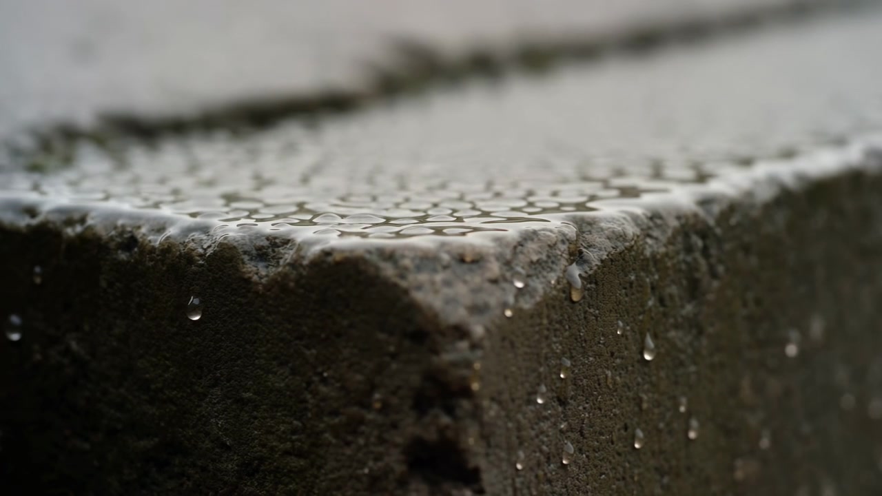 Neutral betonoverflade på en udendørs byggeplads set oppefra, grå og brune nuancer, nærbillede, i en byudviklingskontekst, ren baggrund, plads til tekst, redaktionel brug