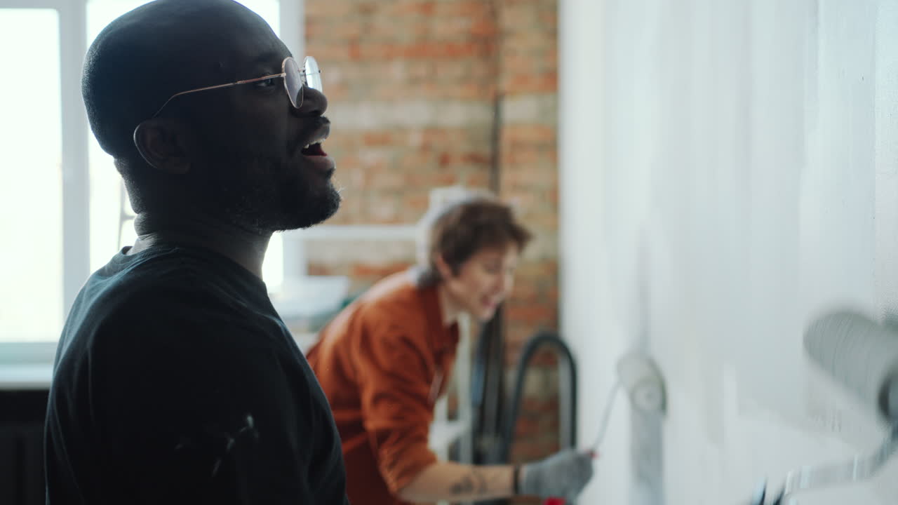 Couple Painting Walls and Chatting as Doing Home Renovation Together