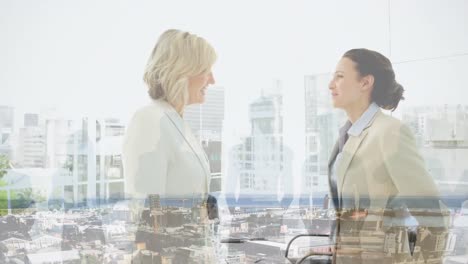 Animation-of-businesswomen-handshake-over-cityscape