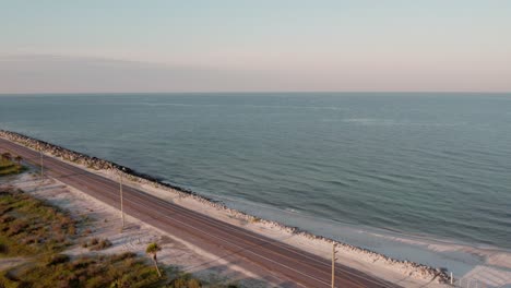 aerial flight over a highway and rock retaining wall between the gulf of mexico and st