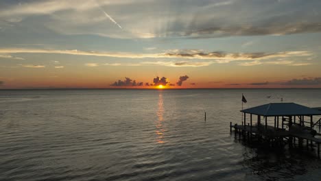 sunsetting over mobile bay while boaters play in