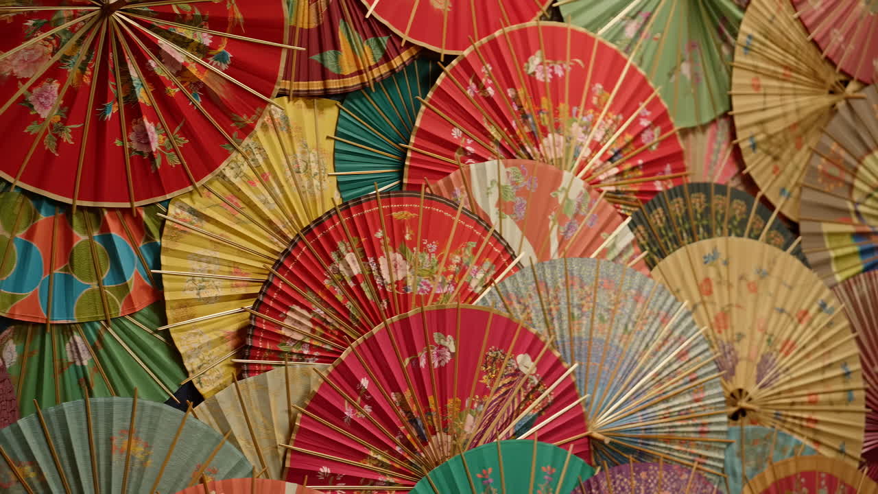 Ventagli a mano e ombrelli di carta tradizionali asiatici colorati esposti
