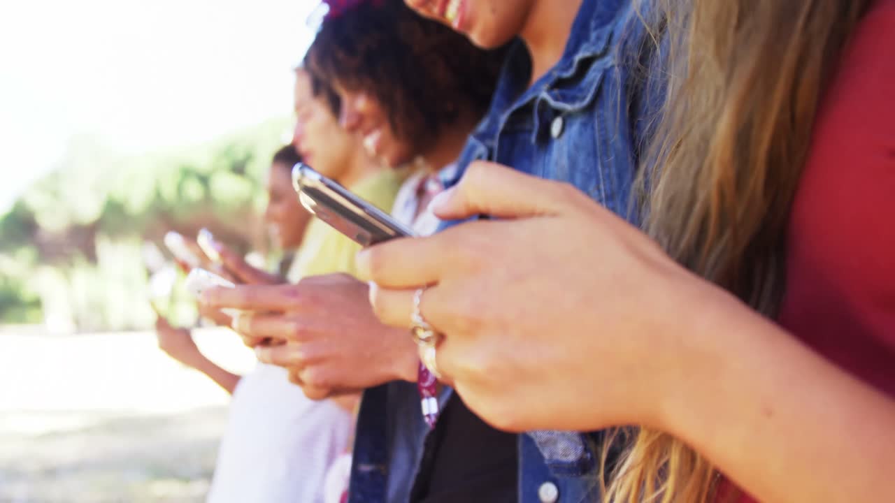 amigos usando teléfono móvil cerca de la furgoneta en el parque 4k