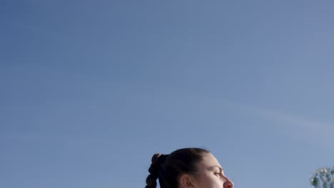 Young woman dancing outdoors under blue sky