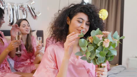 mujer musulmana sosteniendo ramo, vistiendo camisón de seda rosa, sonriendo y mirando a la cámara 1