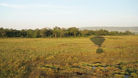 Paseo-En-Globo-Aerostático,-Vista-Alta-Volando-Sobre-El-Paisaje-Masai-Mara-En-áfrica,-Toma-Aérea-Del-Hermoso-Paisaje-De-La-Sabana-Africana-Al-Amanecer-En-Una-Experiencia-De-Viaje-Increíble,-Viaje-En-Globo-De-Lujo