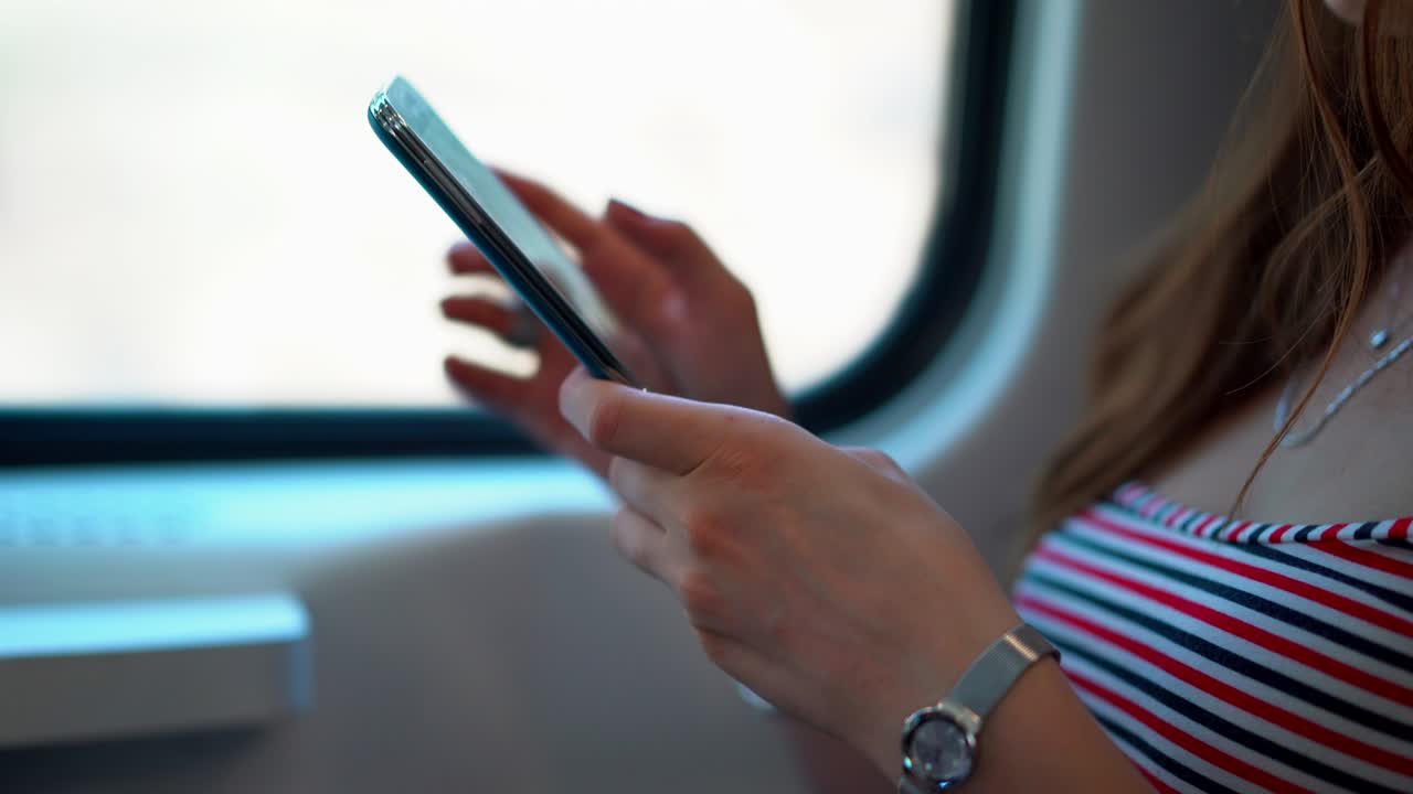 mujer atractiva usando su teléfono inteligente en un tren en movimiento. 4k (uhd