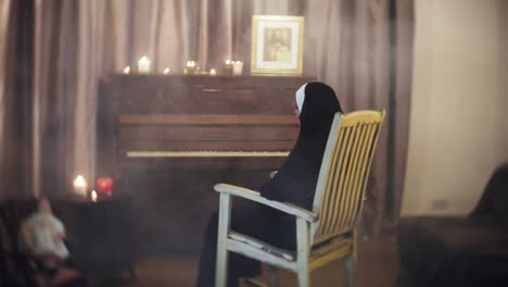 spooky creepy nun in a horror scene, rocking in a rocking chair in a living room with a piano, a doll and candles