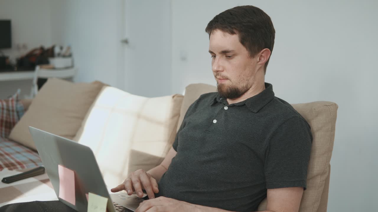 집에서 소파에서 노트북으로 일하는 남자