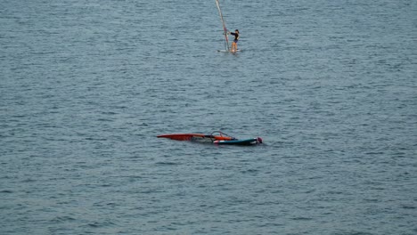 Gente-Coreana-Haciendo-Windsurf-En-El-Río-Han,-Parque-Ttukseom,-Seúl,-Un-Hombre-En-El-Agua-Sosteniendo-Una-Tabla-Después-De-Perder-El-Equilibrio-Y-Estrellarse