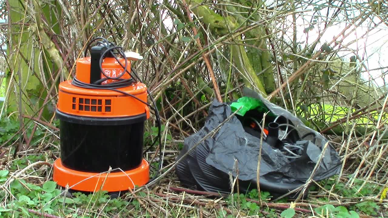 bolsa de plástico llena de cables eléctricos y un equipo naranja con punta de mosca en la campiña inglesa
