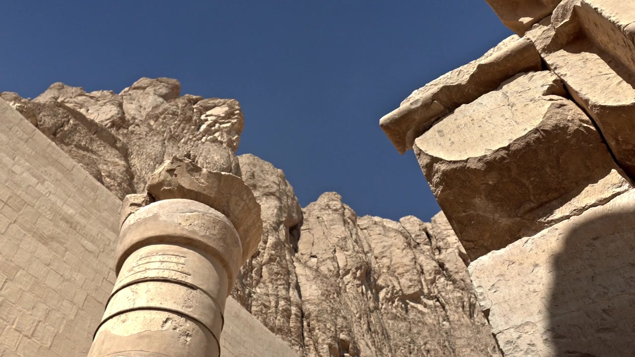 Perspektif sudut rendah yang simetris menunjukkan arsitektur batu monumental di Kuil Makam Hatshepsut (Deir el-Bahari) di Luxor, Mesir.