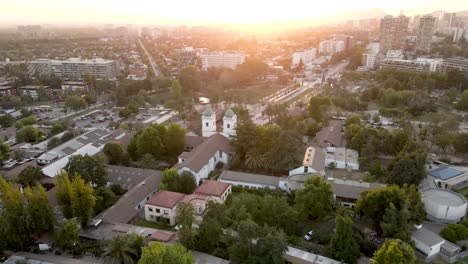 toma de drones de una órbita de la iglesia de los dominicos en santiago de chile con la puesta de sol en el fondo - vista aérea