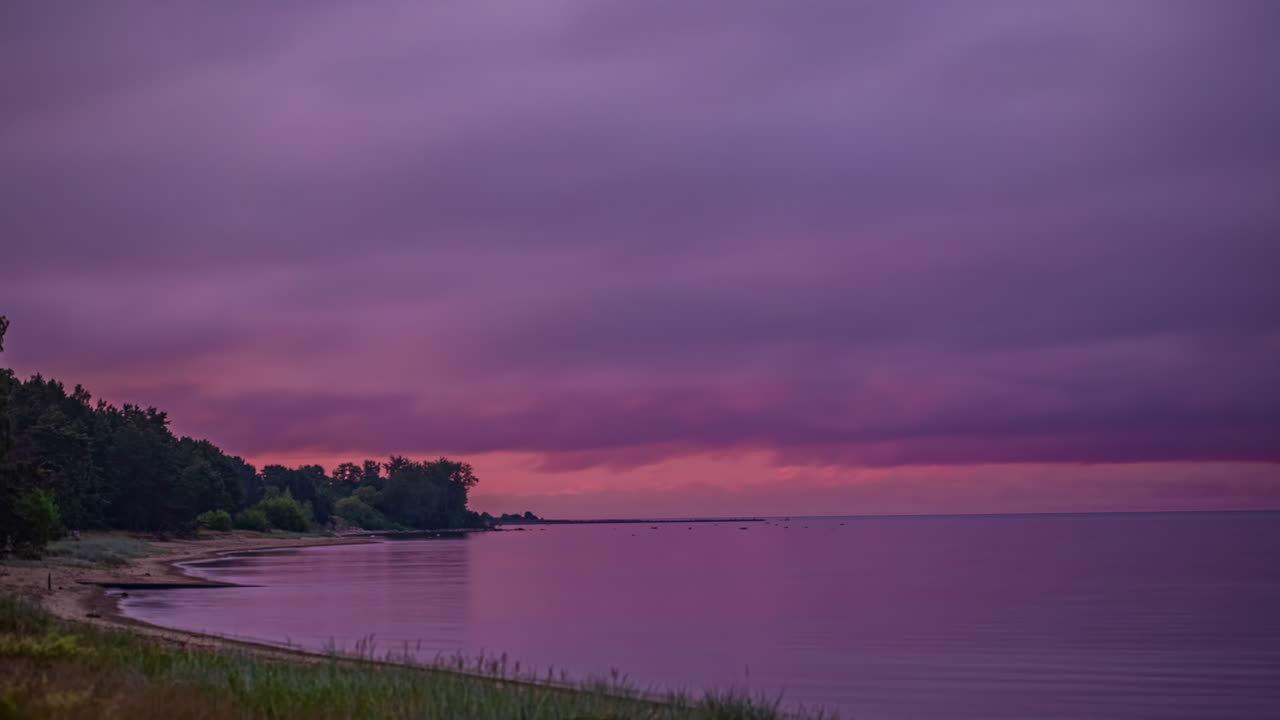 místicas nubes oscuras volando sobre la playa de arena del océano después de la puesta de sol rosa - lapso de tiempo