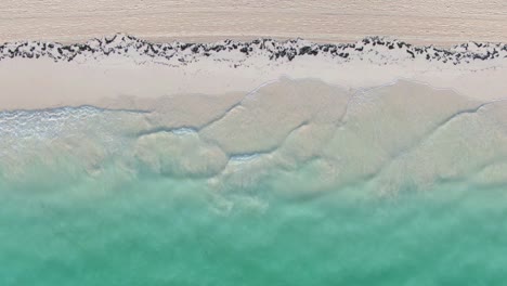 turquoise sea and white sand on tropical beach, top down aerial seascape view, nobody, tranquil and serene scene, travel, solitude and wanderlust concept