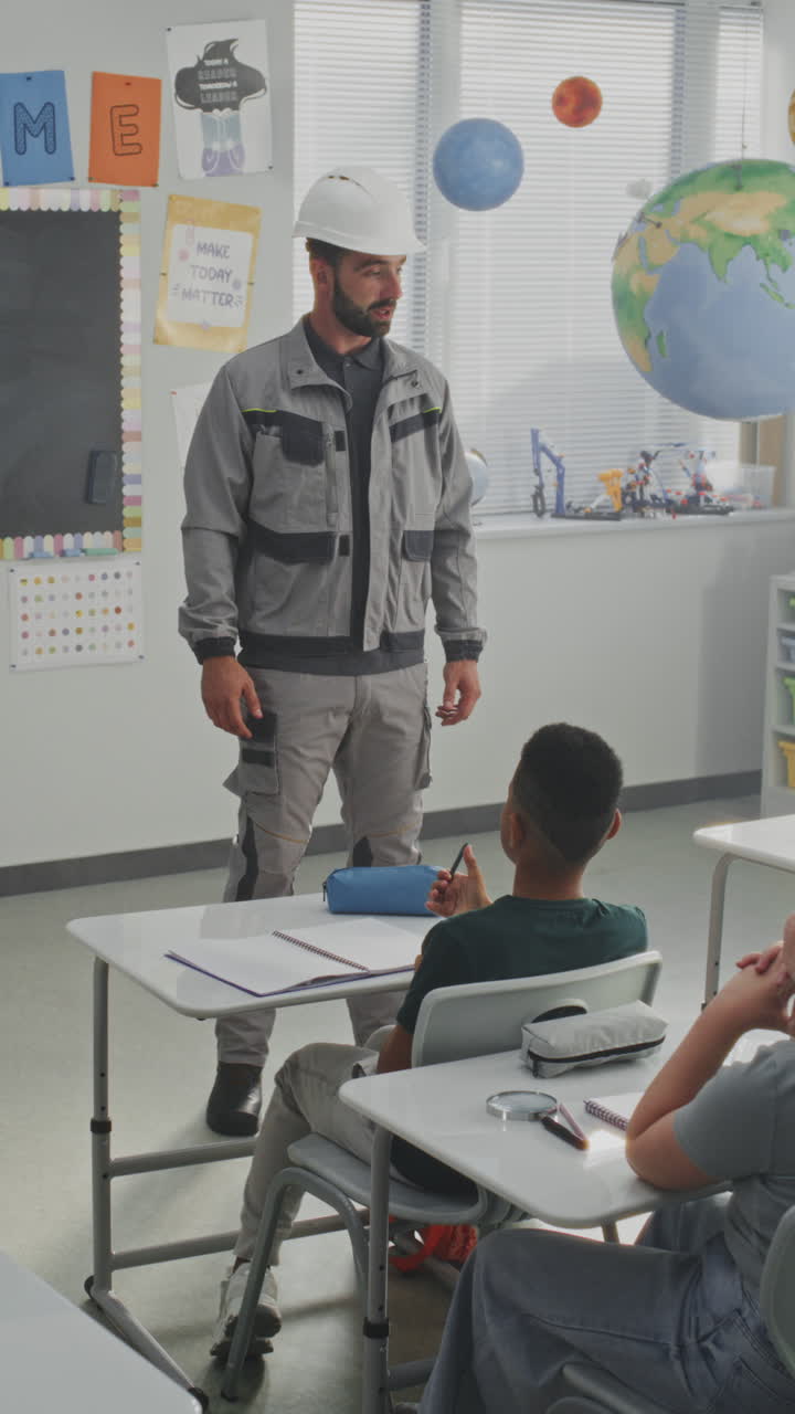 Engineer in Uniform Speaking and Giving Lecture to Curious Primary School Students About Engineering