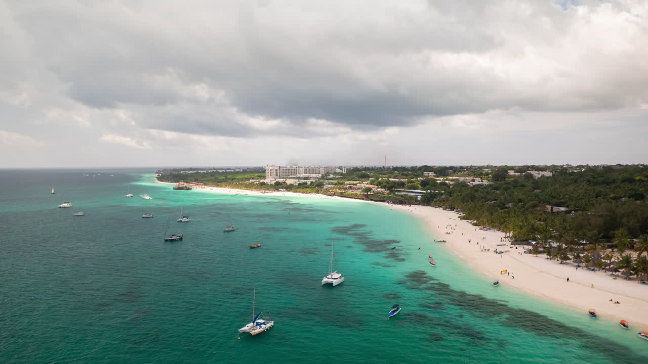 관광객과 지역 주민이 색과 기을 혼합하는 잔지바르 해변, 여름 휴가 개념, 탄자니아 켄드와 해변의 공중 풍경, 24fps로 촬영 된 타임 스