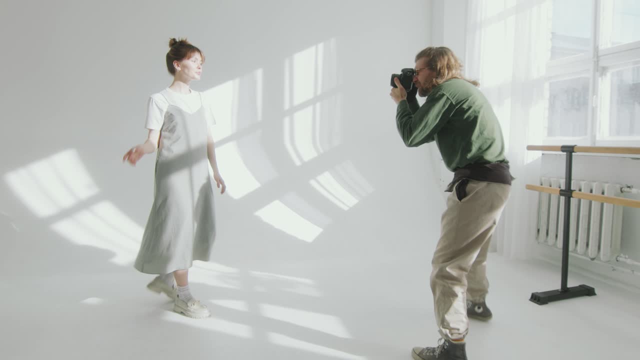 Beautiful Model Posing on White Cyc Wall in front of Photographer