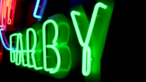 close shot of a green polish neon in slow motion in a dark room