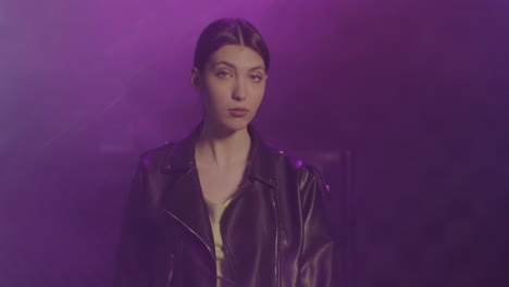 Beautiful-Girl-In-Leather-Jacket-Looking-Confidently-At-Camera-While-Dancing-At-Disco