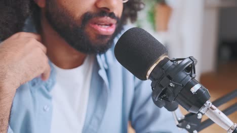 closeup of microphone and mouth of young bearded arabian man blogger