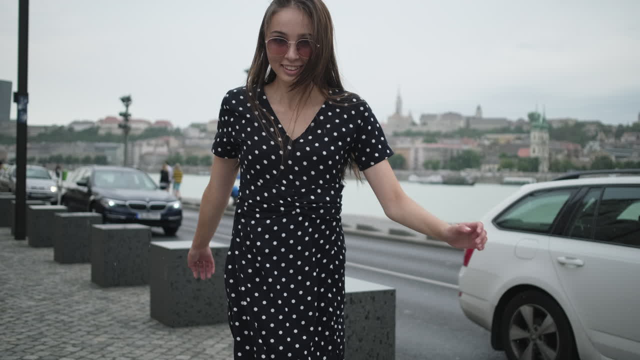 Donna che cammina per una via della città in una giornata nuvolosa