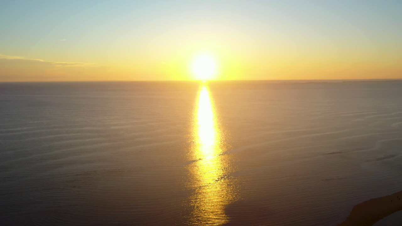 Beautiful Ocean Sun Set Aerial Drone Footage of Bright Sun Touching Horizon and Casting Reflection of Light Across Water