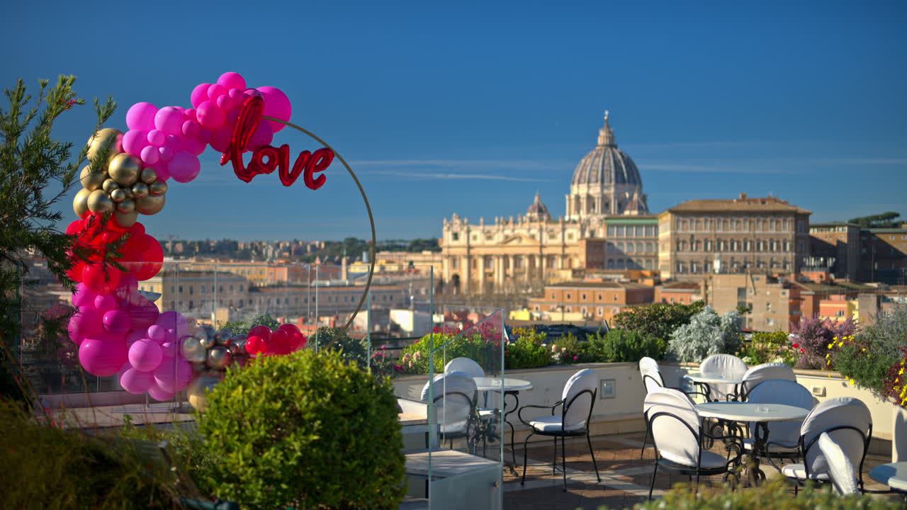 Pink, red and gold, love balloon arch at a restaurant with panoramic view of Vatican City, Rome, Italy