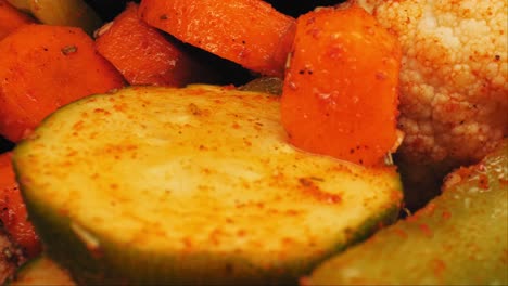 primer plano cinematográfico de popurrí de verduras a la parrilla (calabacín, zanahorias, coliflor, sazonado con hierbas) filmado con una lente de sonda macro
