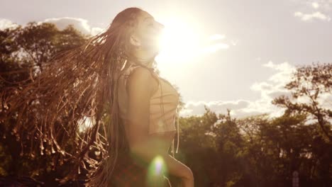 hermosa mujer con dreads peinado y sacudiendo la cabeza en el hijo. feliz tranquila chica atractiva con dreads largos divirtiéndose